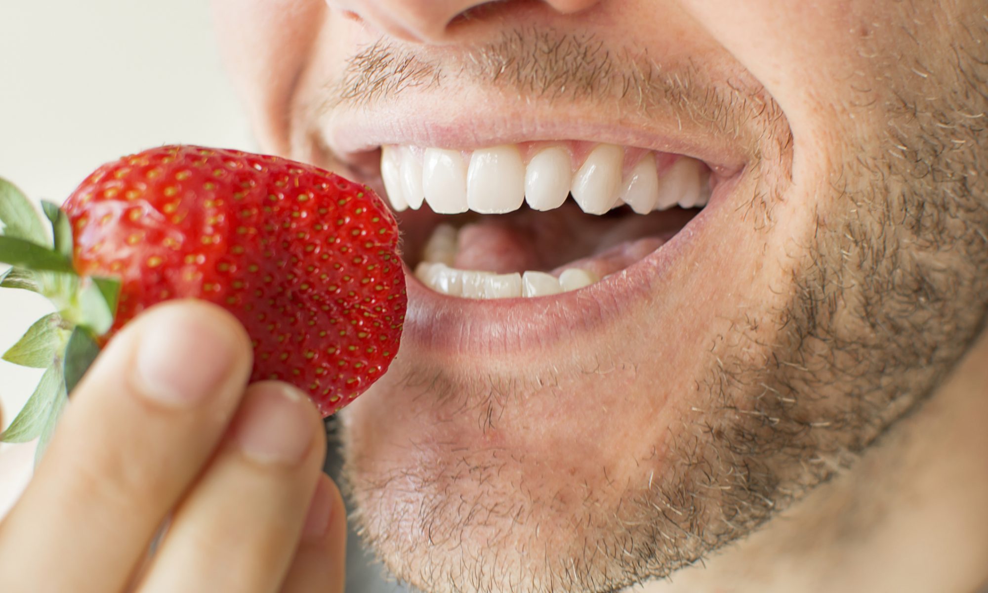 man eating a strawberry